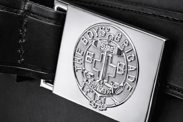 Boys' Brigade badge on a leather belt, symbolizing youth organization.